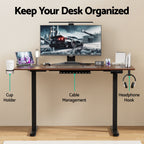 Front view of an ergonomic standing desk workstation highlighting the integrated cup holder, cable management and headphone hook accessories.