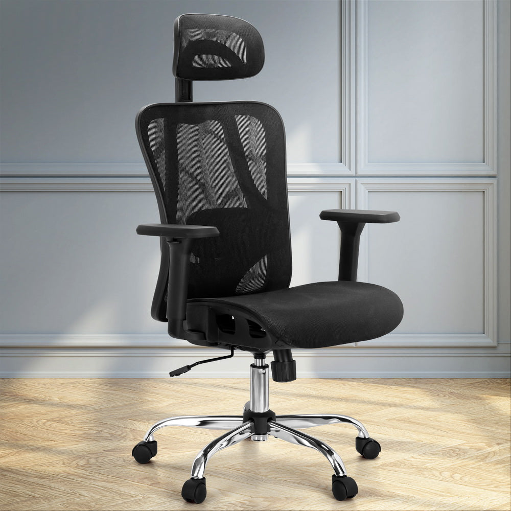 Black ergonomic mesh desk chair positioned in a bright, modern home office space with timber flooring.