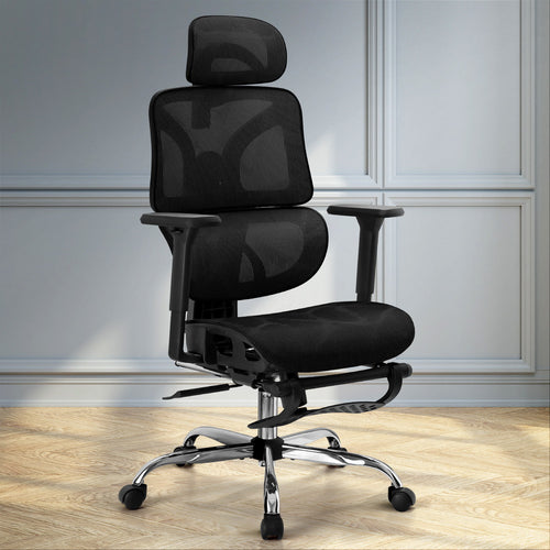 Black ergonomic mesh desk chair with footrest set up in a modern home office space with timber flooring.