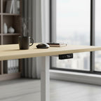 Cloud Office Studio white oak standing desk with digital control panel, coffee mug, and mouse in a home office.